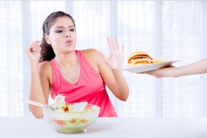 lady rejecting burger and fries